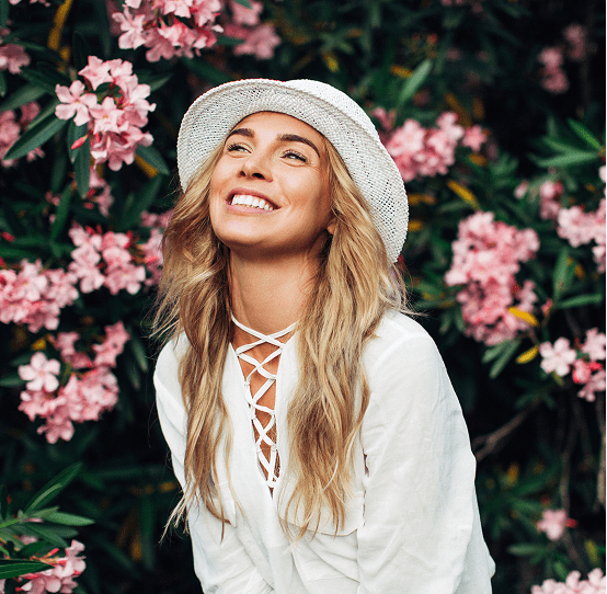 Woman smiling near pink flowers